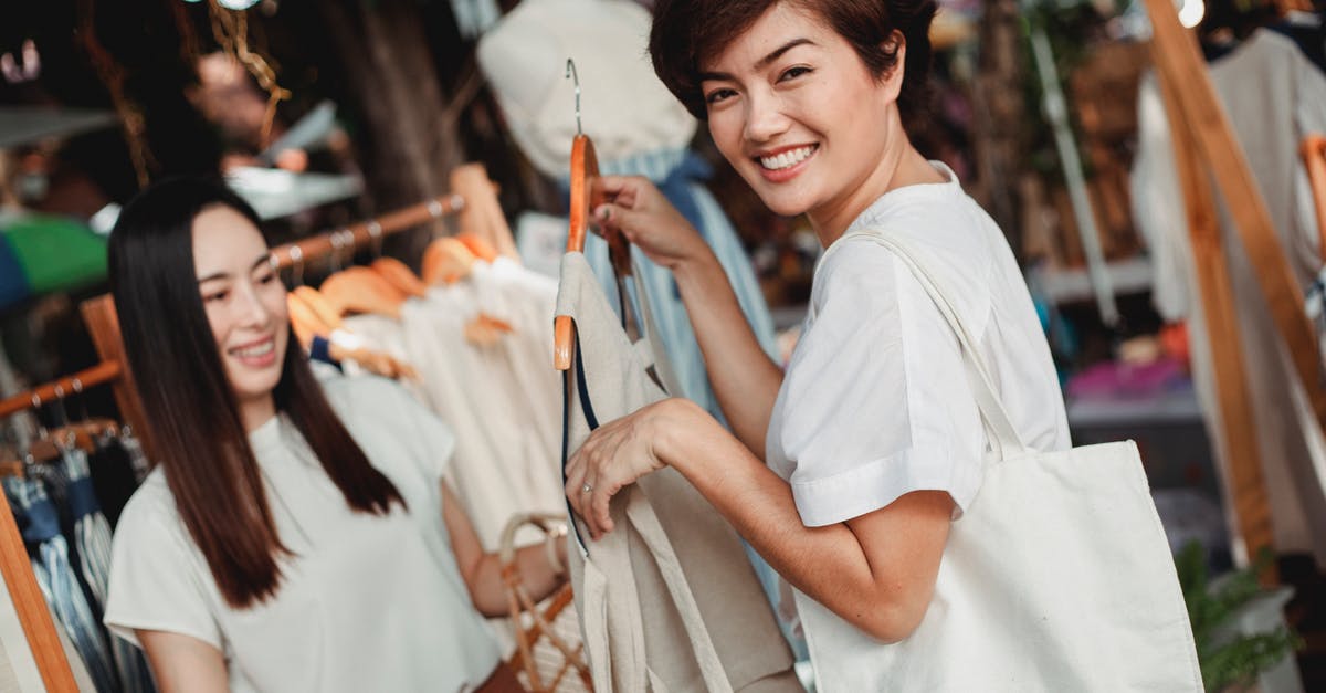 How to choose flights more environmentally friendly based on adding stopovers versus (ultra-)long-haul? [closed] - Happy Asian females in stylish summer outfits choosing clothes while standing in sunny street market