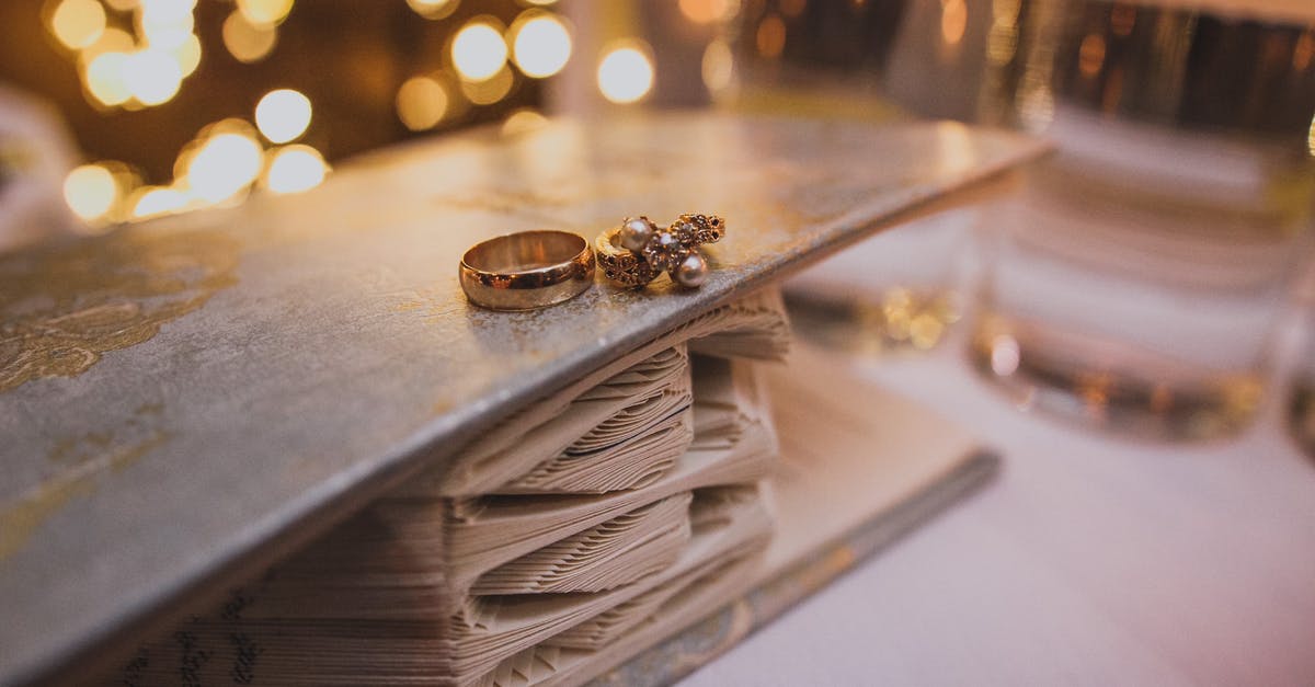 How to claim a refund plus expenses for a changed flight booked through a 3rd party agent [closed] - Golden wedding rings on decorated book in room for celebration with bright shiny lights