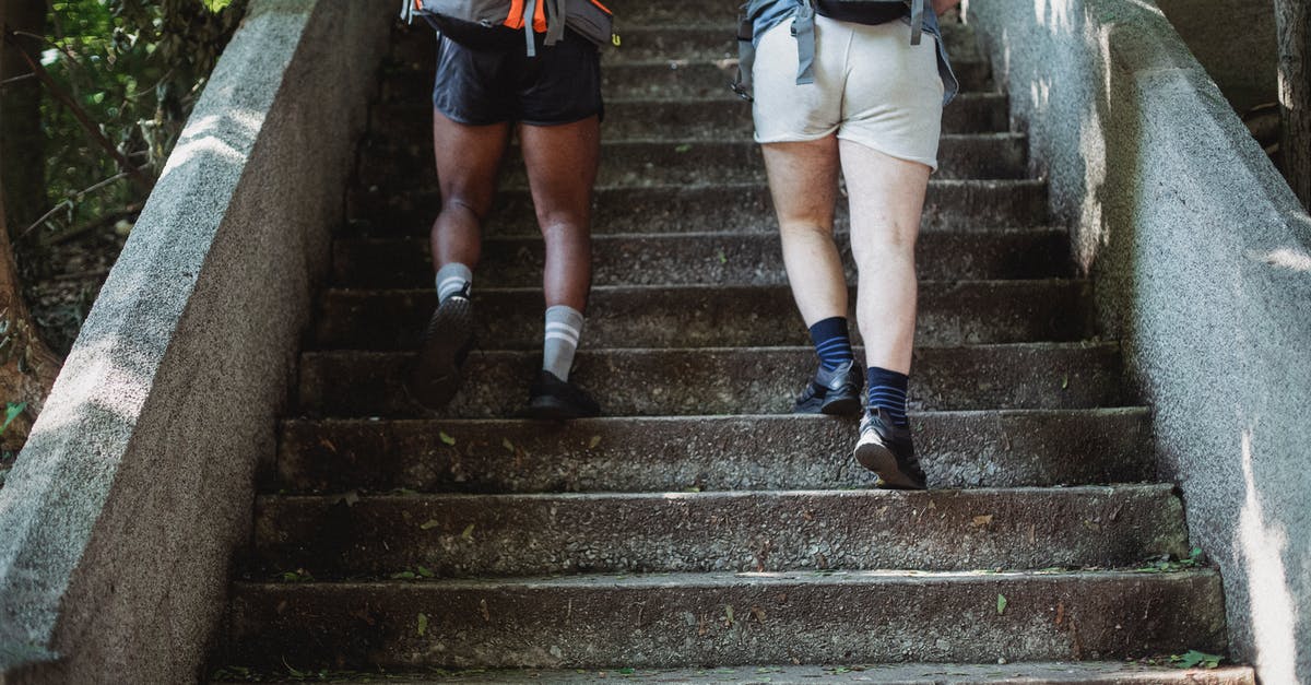 How to decide which way to go up the Eiffel tower? - Travelers walking up stairs in park How to decide which way to go up the Eiffel tower? - Travelers walking up stairs in park