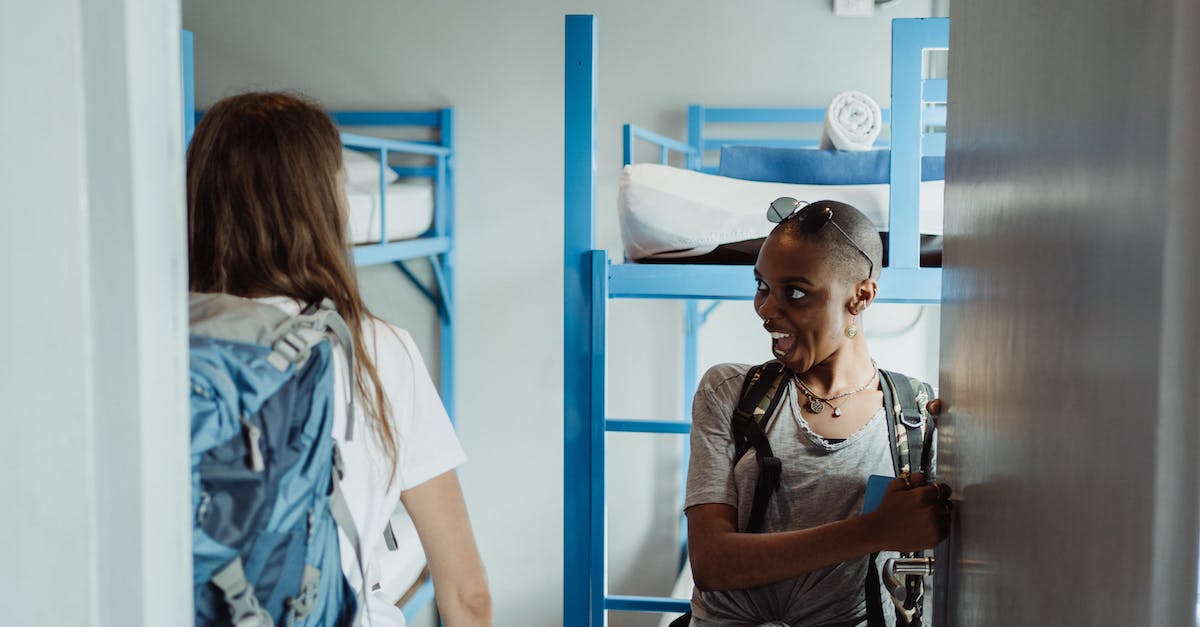 How to determine if a hostel room is a walk-through room? - Women Walking into Their Hostel Room with Bunk Beds and Smiling 