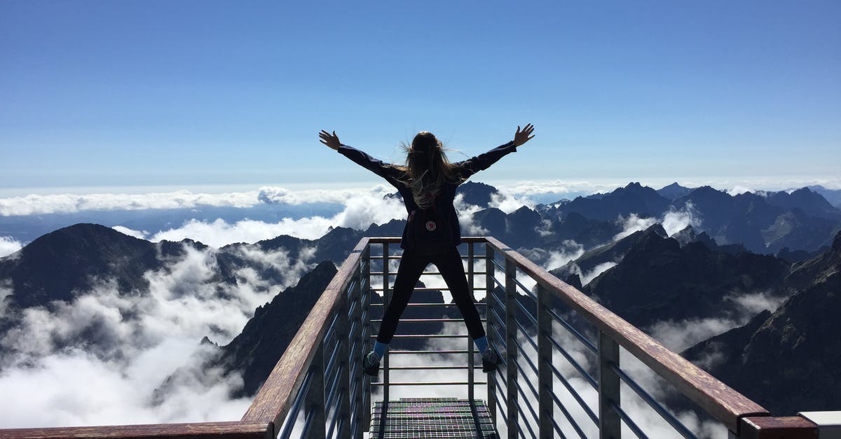 How to enjoy traveling with more people - Person Standing on Hand Rails With Arms Wide Open Facing the Mountains and Clouds How to enjoy traveling with more people - Person Standing on Hand Rails With Arms Wide Open Facing the Mountains and Clouds