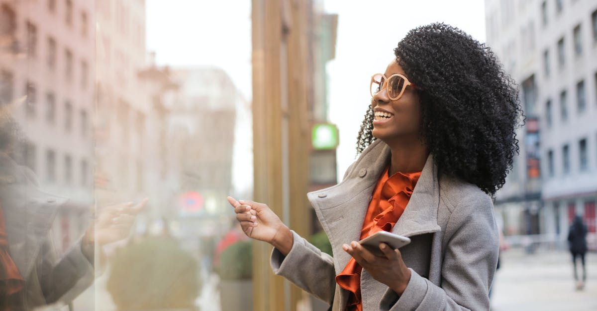 How to enjoy traveling with more people - Happy black woman laughing on street How to enjoy traveling with more people - Happy black woman laughing on street