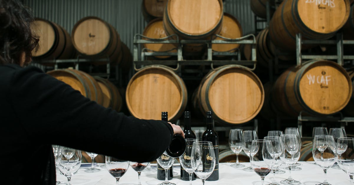 How to fill landing card for UK for back-to-back entries and exits? - Back view of anonymous sommelier pouring wine from bottle into wineglass while standing at table with glassware in winery against barrels How to fill landing card for UK for back-to-back entries and exits? - Back view of anonymous sommelier pouring wine from bottle into wineglass while standing at table with glassware in winery against barrels