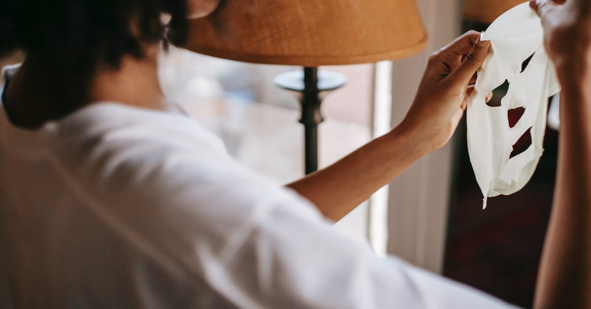 How to find accommodation when what you reserved appears to be overbooked, or worse, non-existent? - Black female holding moisturizing sheet mask in room