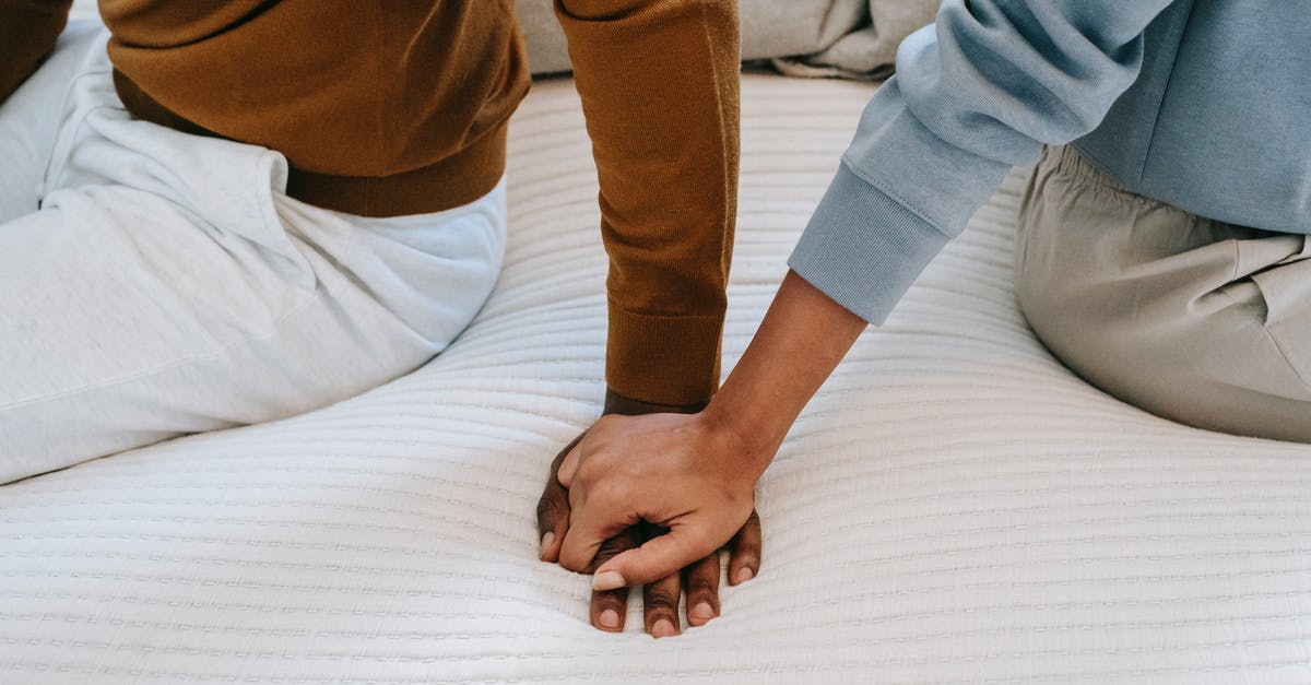 How to find airline seats with separate recline and back support controls? - Crop unrecognizable black couple holding hands on bed