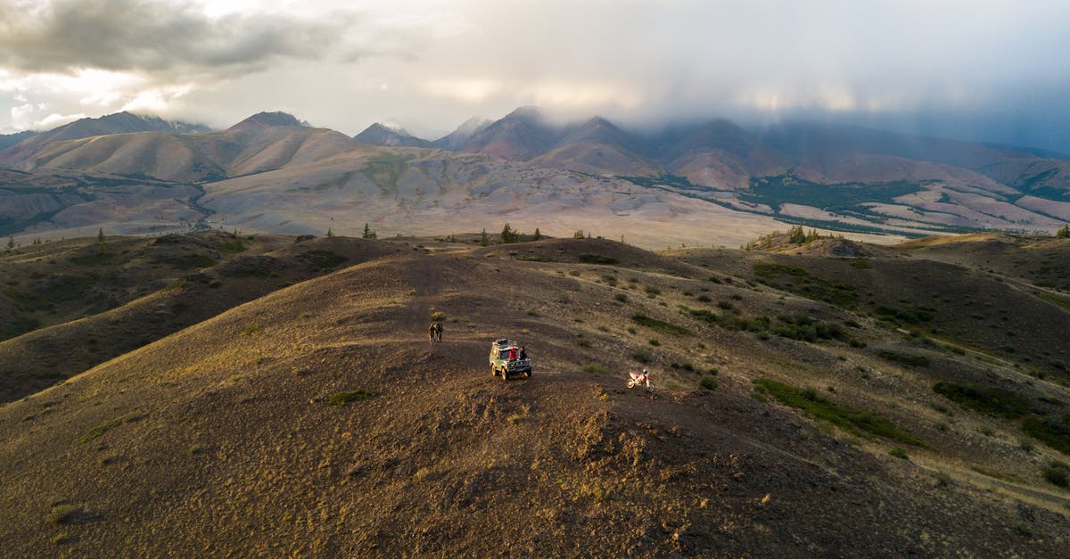 How to find out the peak times and when an off peak ticket is valid - Aerial view of car and anonymous travelers walking on top of hill against mountain ridges and desert valleys
