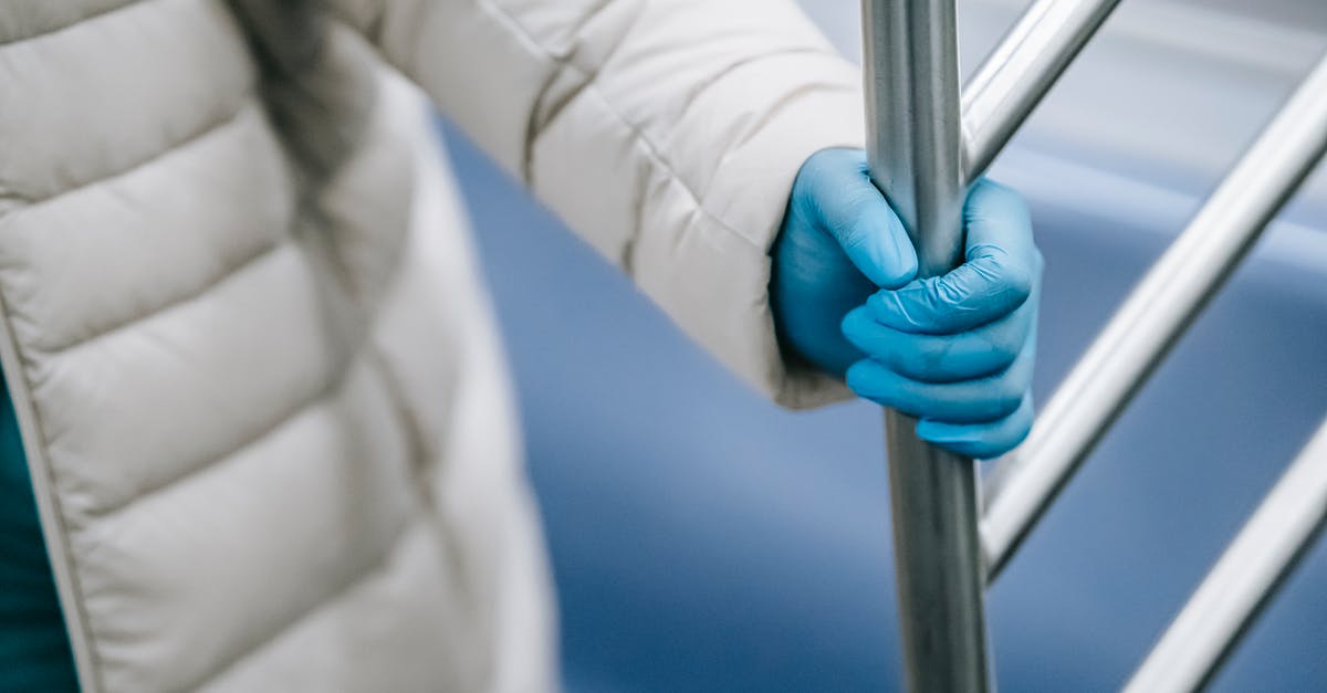 How to find safe places to travel during the pandemic? - Crop unrecognizable person grasping handle in metro train How to find safe places to travel during the pandemic? - Crop unrecognizable person grasping handle in metro train