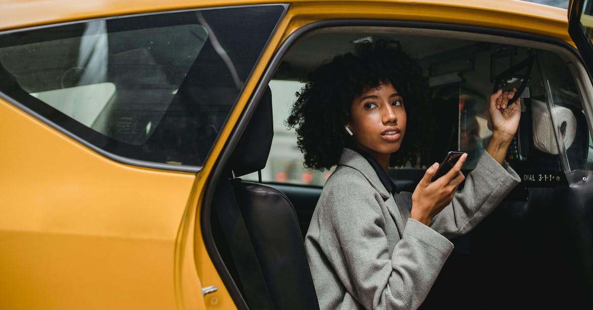 How to get a taxi on Prague streets? - African American woman getting out of yellow cab How to get a taxi on Prague streets? - African American woman getting out of yellow cab