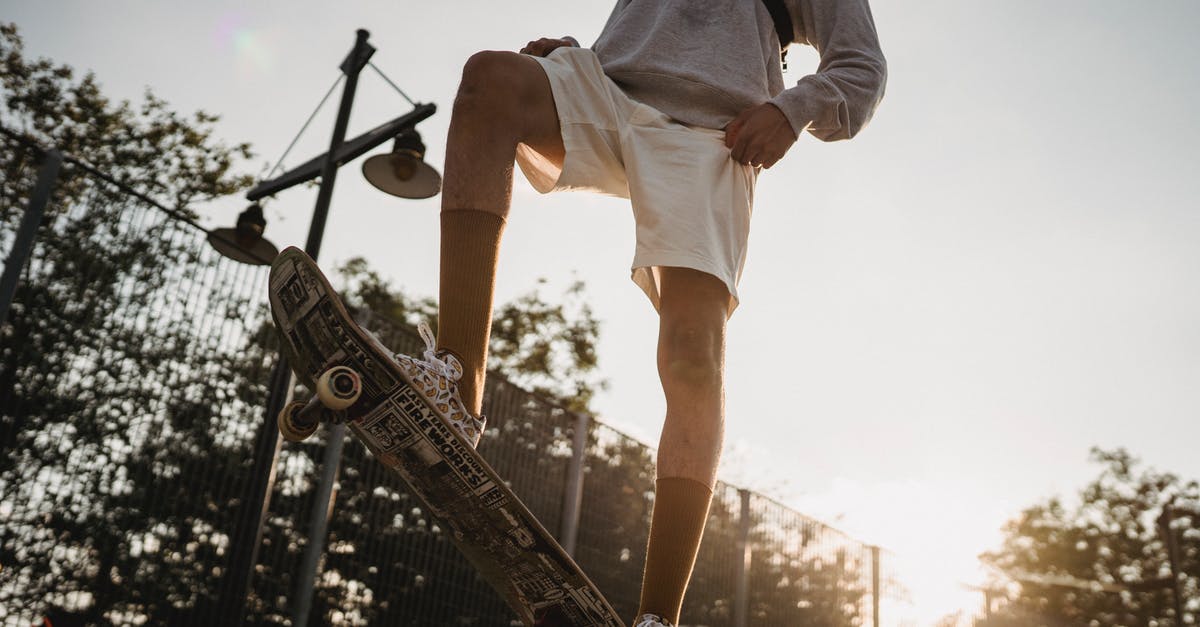 How to get from Belize City to Tikal? - Crop sportsman preparing for skateboarding on skate ramp at sunset