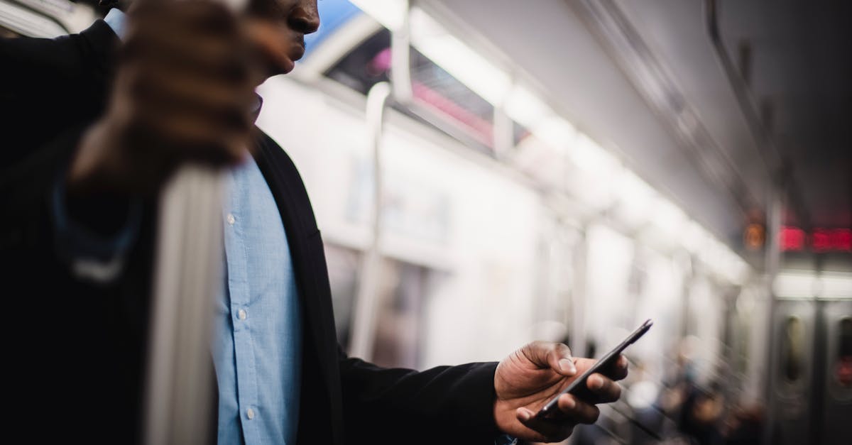how to get from Grodno to Bahatyrevičy with public transport - Black man using mobile while commuting by train how to get from Grodno to Bahatyrevičy with public transport - Black man using mobile while commuting by train