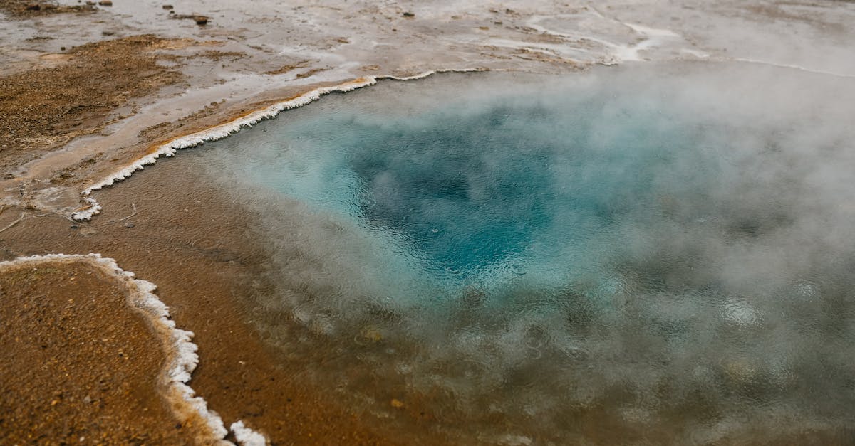 How to get from Iceland to Greenland? - High angle picturesque scenery of hot geyser with crystal clear blue water on sandy terrain How to get from Iceland to Greenland? - High angle picturesque scenery of hot geyser with crystal clear blue water on sandy terrain