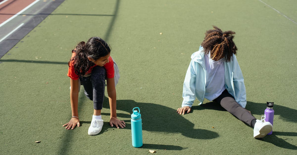 How to get from Split to Supetar by ferry? - Black girl doing split while friend stretching before training on stadium How to get from Split to Supetar by ferry? - Black girl doing split while friend stretching before training on stadium