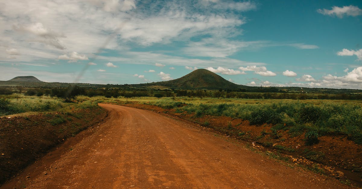 How to get into and travel across Tanzania - Photo of Dirt Road Across Hill Under Cloudy Sky How to get into and travel across Tanzania - Photo of Dirt Road Across Hill Under Cloudy Sky