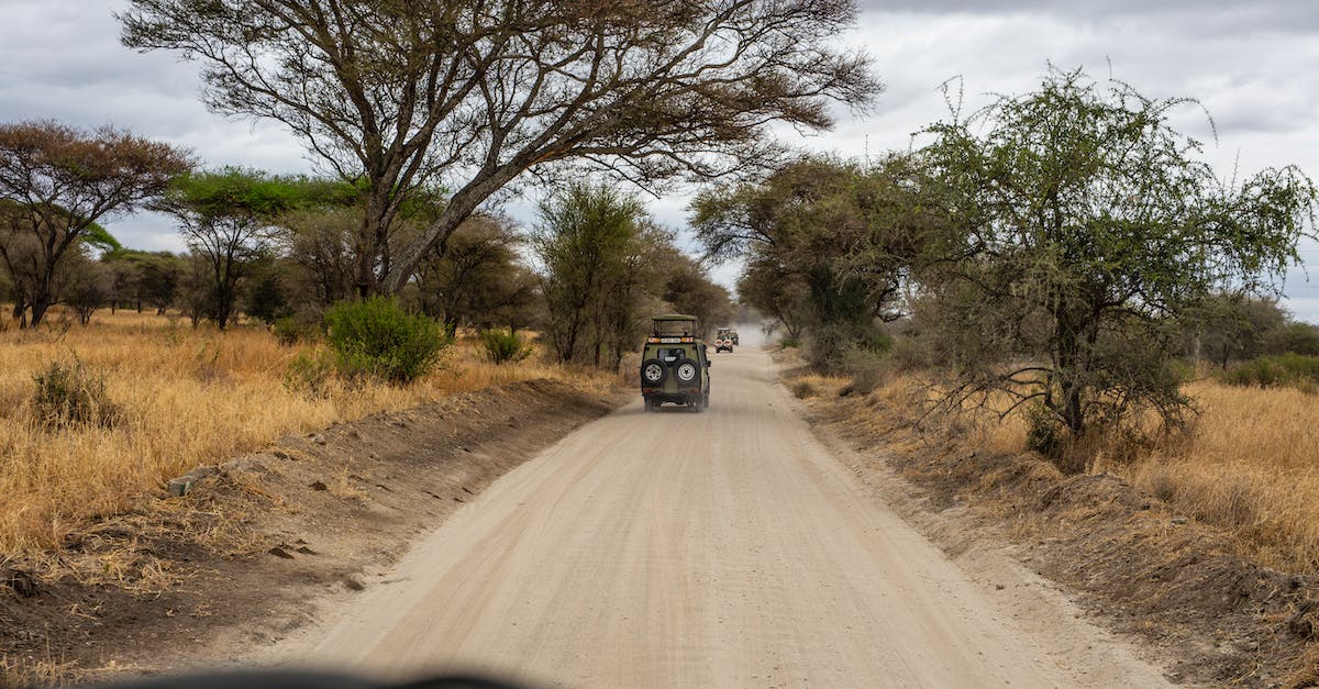 How to get into and travel across Tanzania - A Convoy of Safari Jeeps on Dirt Road How to get into and travel across Tanzania - A Convoy of Safari Jeeps on Dirt Road