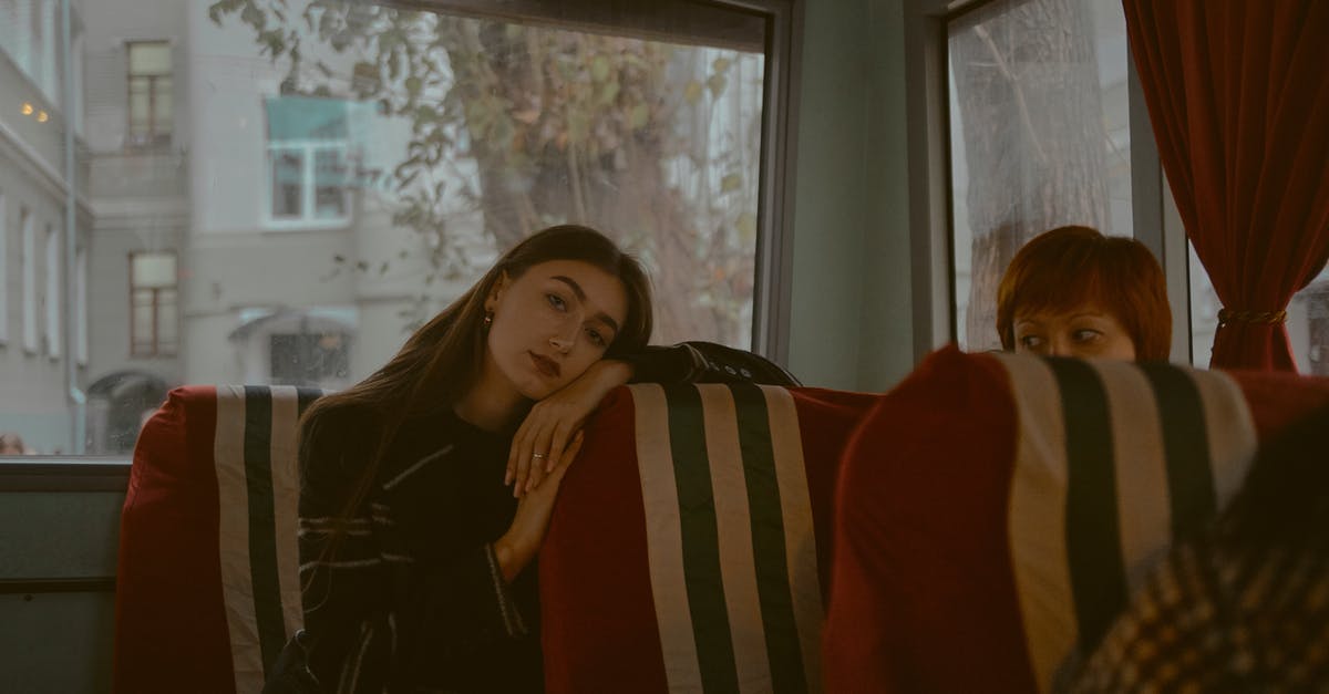How to get off a London bus when sitting on the top deck? - Woman in Black and White Striped Long Sleeve Shirt Beside Woman in Red Long Sleeve Shirt