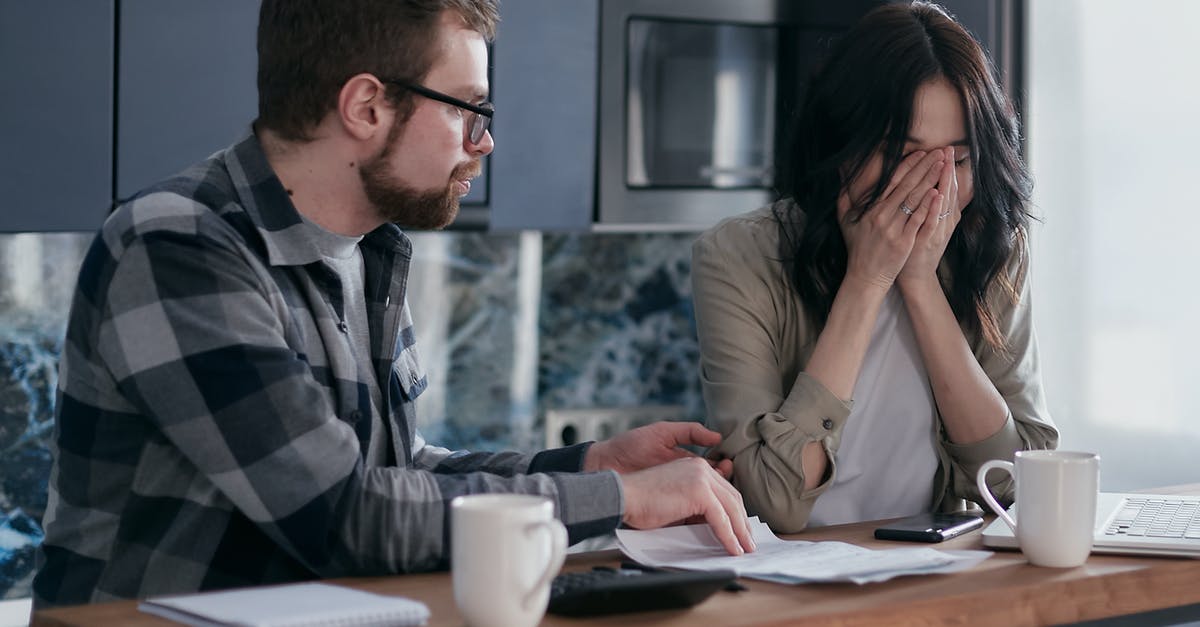 How to go about paying bills at home during an overseas trip? - Man in Black and White Plaid Dress Shirt Sitting Beside Woman in Brown Long Sleeve Shirt How to go about paying bills at home during an overseas trip? - Man in Black and White Plaid Dress Shirt Sitting Beside Woman in Brown Long Sleeve Shirt