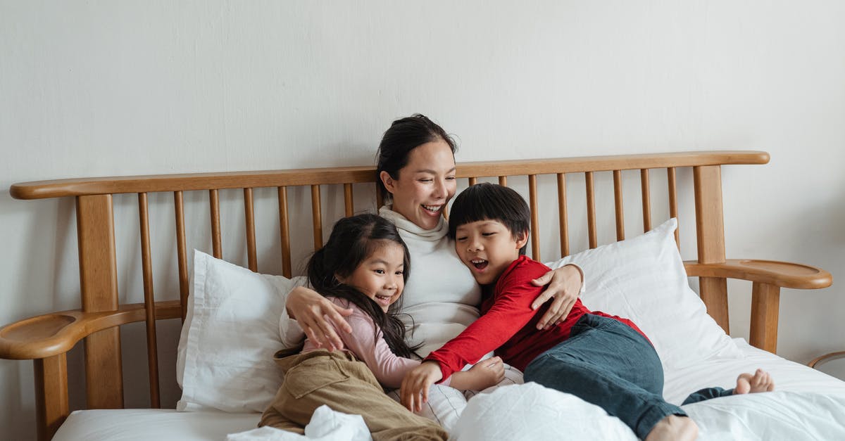 How to have fun in Bouillon, Belgium [closed] - Cheerful ethnic mother hugging children lying in bed