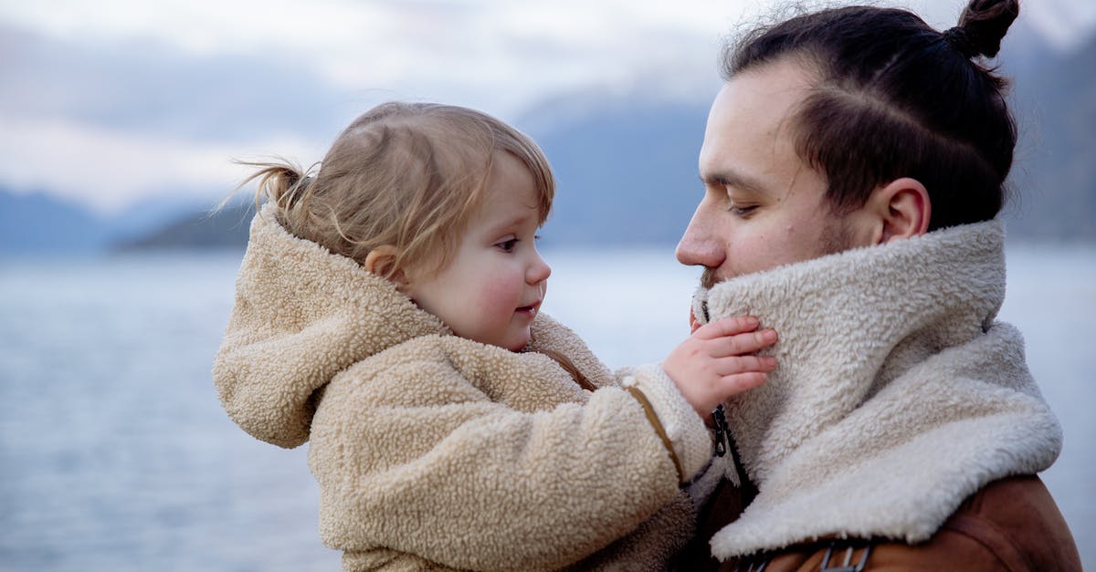 How to keep electronics warm in cold countries? - Satisfied young father and little daughter near sea in cold season How to keep electronics warm in cold countries? - Satisfied young father and little daughter near sea in cold season