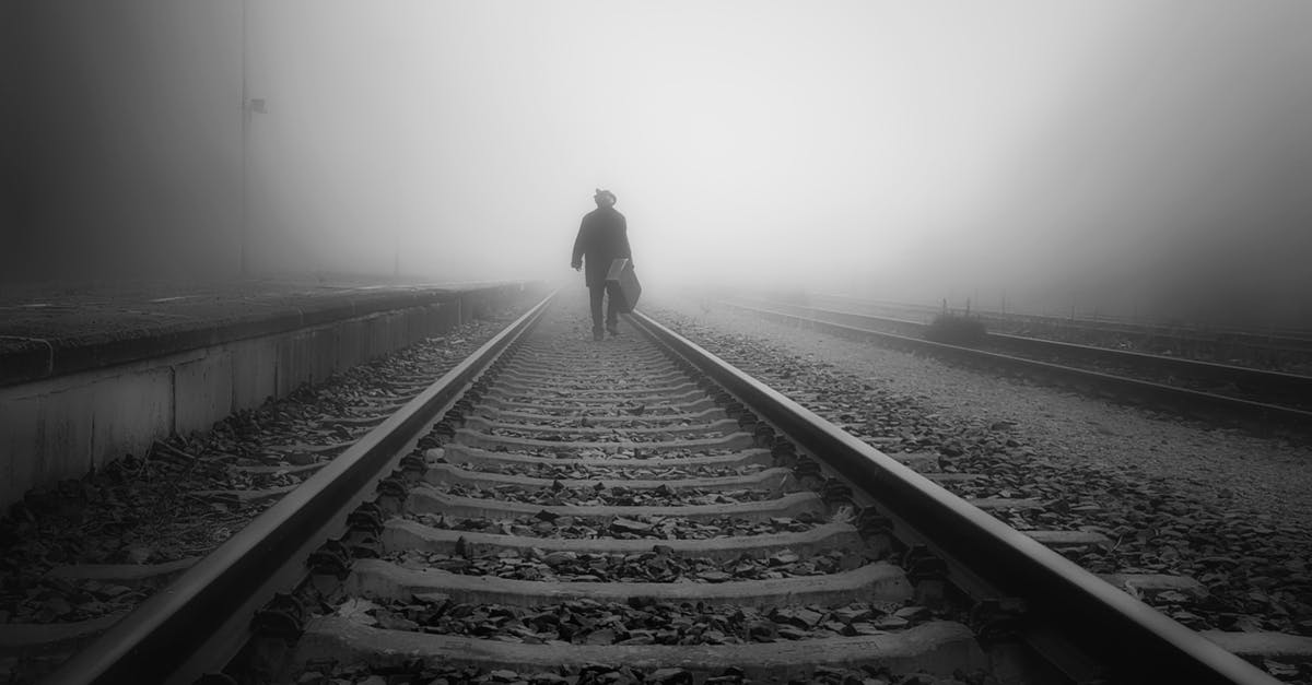 How to keep track of all things you are carrying in the luggage and where they are? - Man Carrying a Luggage Walking on a Railroad Track