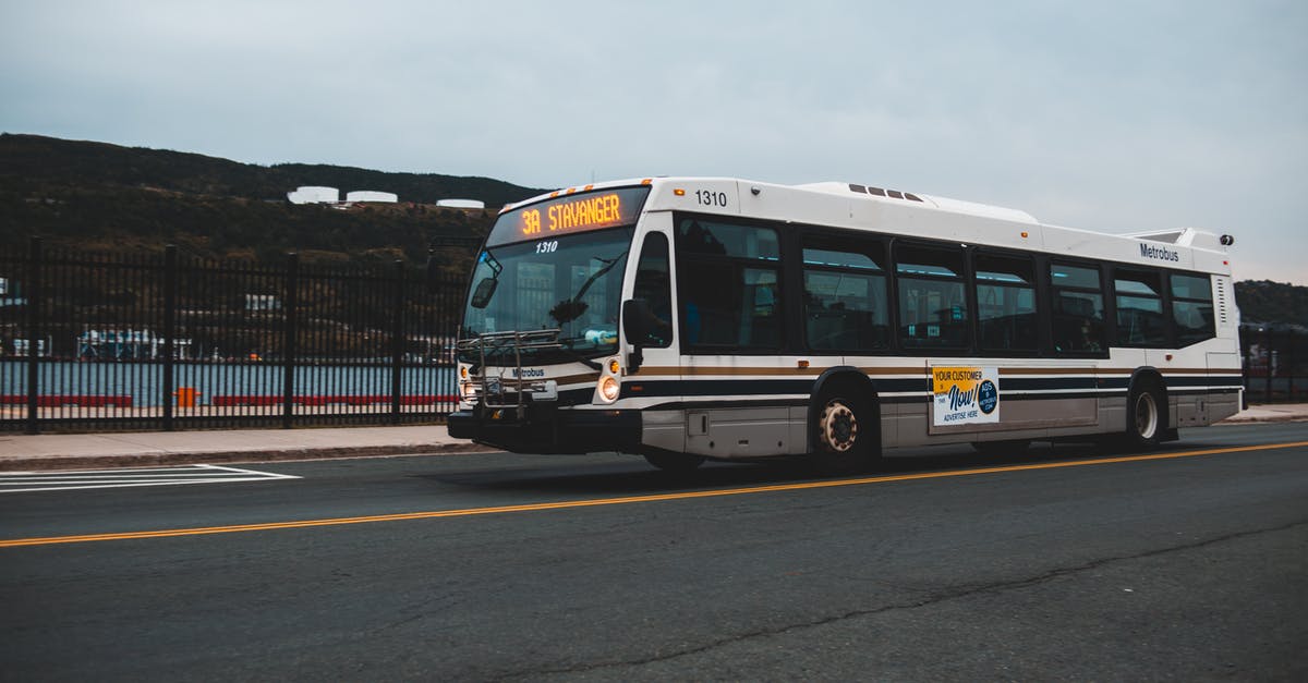 How to manage a longer transit location in a cheaper way - Big gray bus driving on asphalt highway along metal fence near water against cloudless sky with mountains in distance outside How to manage a longer transit location in a cheaper way - Big gray bus driving on asphalt highway along metal fence near water against cloudless sky with mountains in distance outside