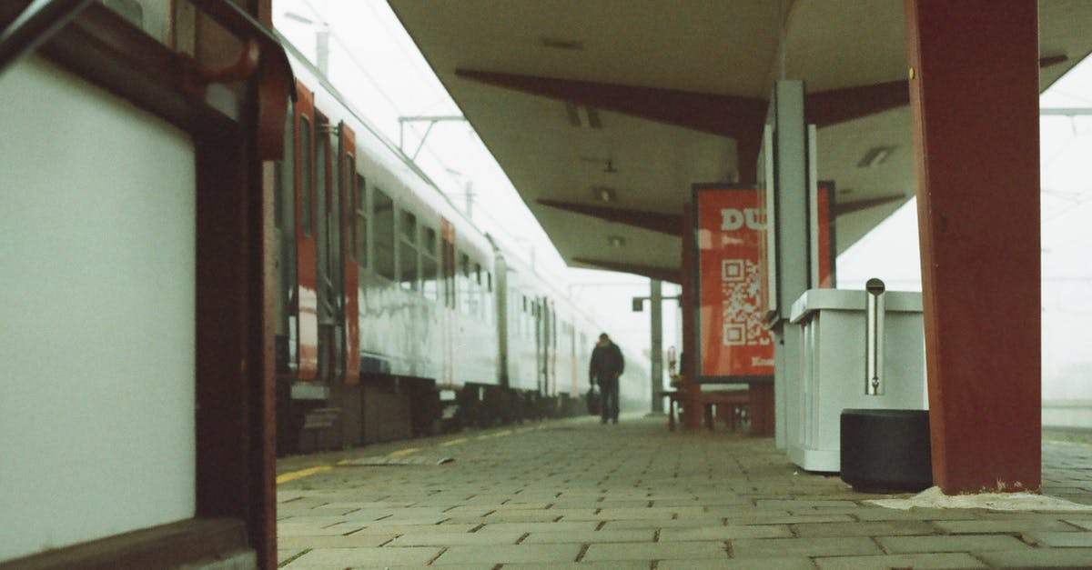How to manage a longer transit location in a cheaper way - Unrecognizable male traveler walking on platform of railway station near modern train against cloudy sky How to manage a longer transit location in a cheaper way - Unrecognizable male traveler walking on platform of railway station near modern train against cloudy sky