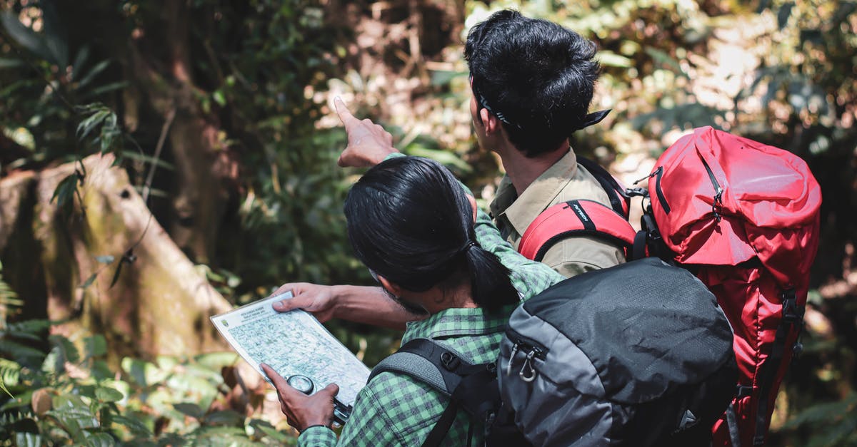 How to Plan a Route for Long Distance Bike Trip In Europe - Male tourists with map standing in forest How to Plan a Route for Long Distance Bike Trip In Europe - Male tourists with map standing in forest