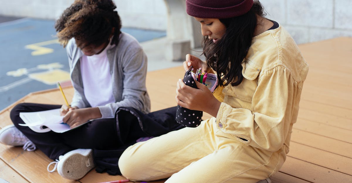 How to process a delayed/lost baggage case? - Crop Hispanic schoolgirl with pencil case sitting near anonymous black girlfriend writing in copybook while doing homework on wooden platform