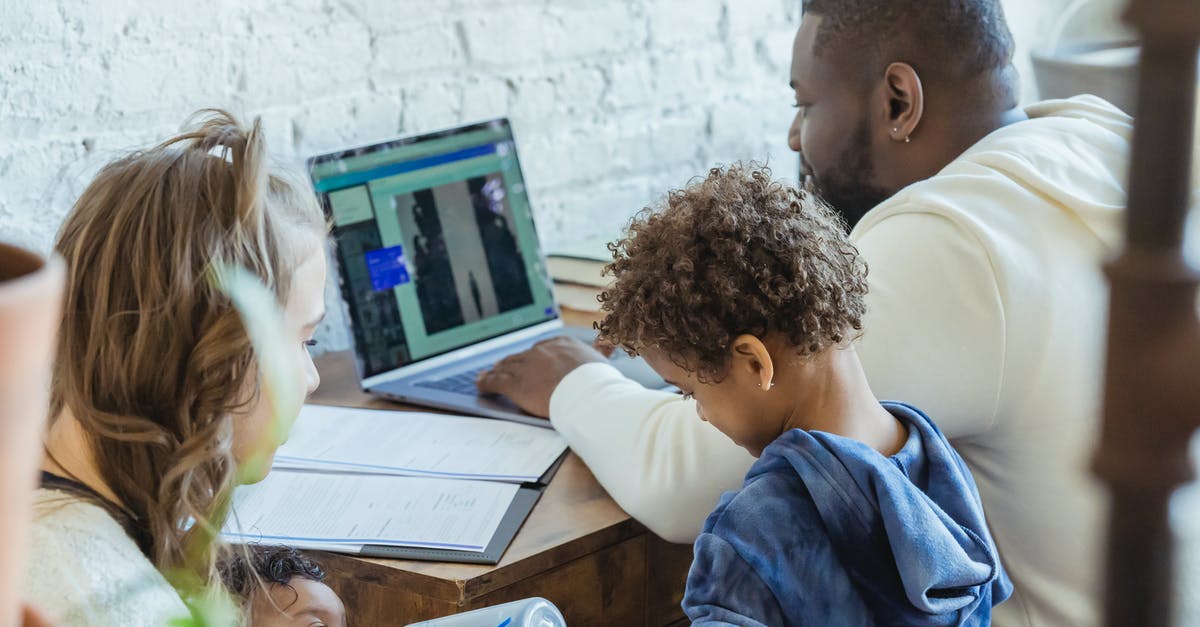 How to prove mother-child relationship for baby passport if mother's name on birth certificate is different from current legal name? - High angle of African American dad watching laptop working near son playing toys and mother feeding little infant