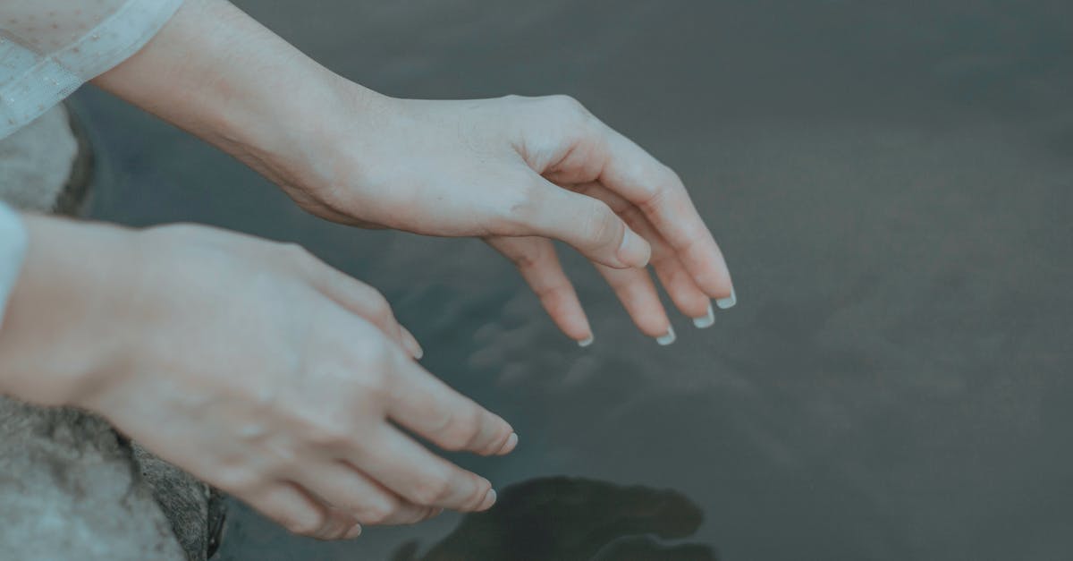 How to reach Salar de Uyuni from Potosí or Sucre (Bolivia)? - Crop anonymous female in elegant clothes reaching hands to calm water in daytime How to reach Salar de Uyuni from Potosí or Sucre (Bolivia)? - Crop anonymous female in elegant clothes reaching hands to calm water in daytime