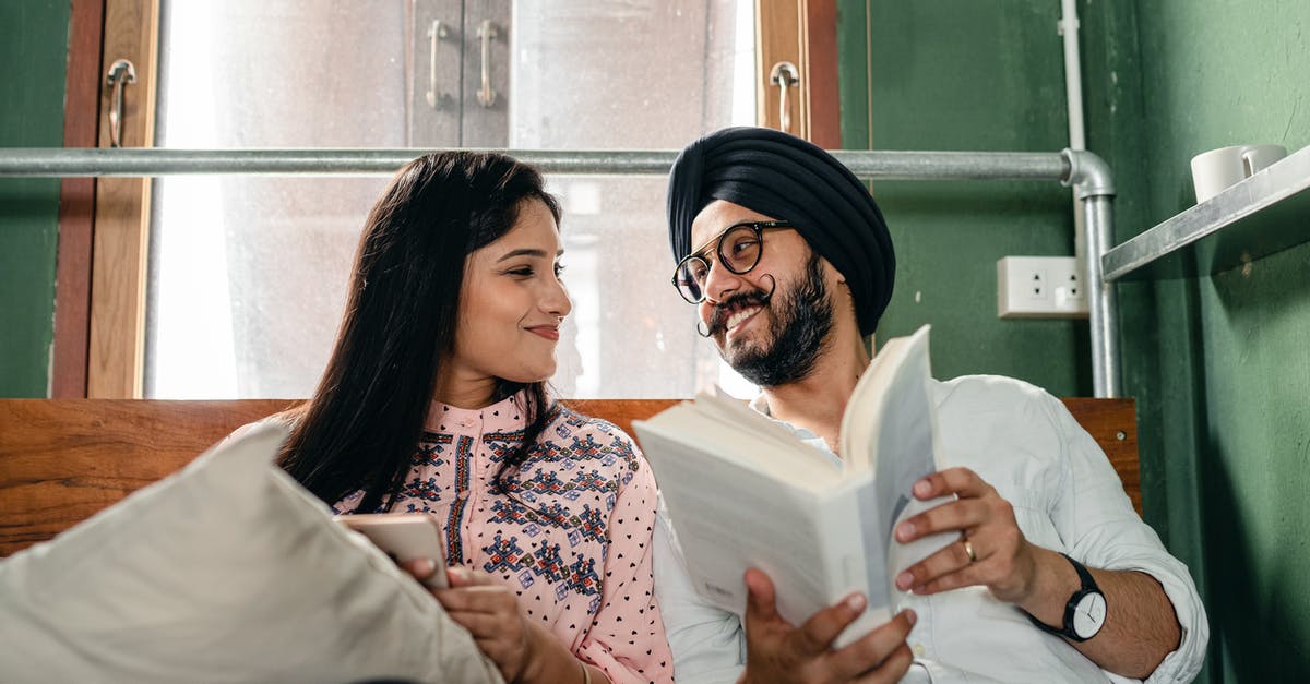 How to read or modify other traveler's date of birth for United Airlines flights? - Loving young Indian couple in casual wear and turban with book and mobile phone resting on comfy bed and looking at each other happily How to read or modify other traveler's date of birth for United Airlines flights? - Loving young Indian couple in casual wear and turban with book and mobile phone resting on comfy bed and looking at each other happily