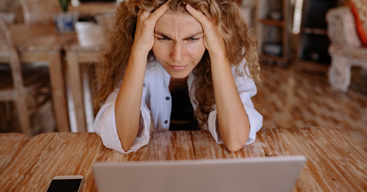How to reduce anxiety about travelling using airplanes? [duplicate] - Photo of Woman Leaning on Wooden Table While Looking Upset