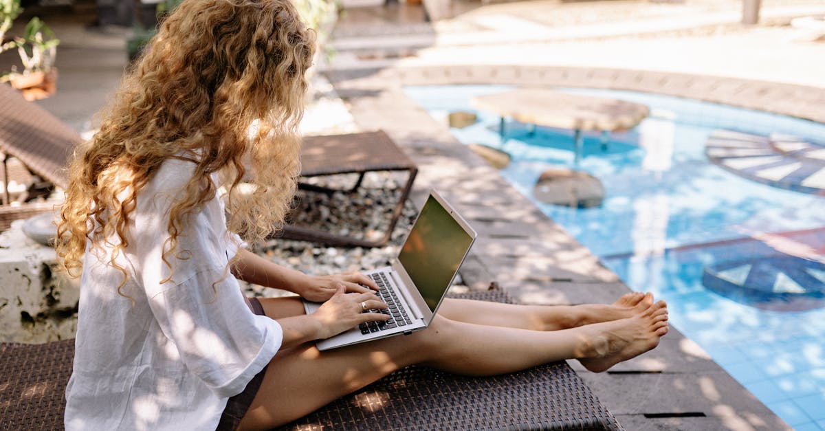 How to search for weekend flights? - From above side view of unrecognizable barefoot female traveler with curly hair typing on netbook while resting on sunbed near swimming pool on sunny day How to search for weekend flights? - From above side view of unrecognizable barefoot female traveler with curly hair typing on netbook while resting on sunbed near swimming pool on sunny day