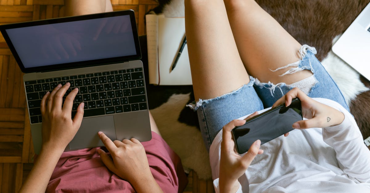 How to search for weekend flights? - From above of crop girlfriends in home clothes sitting on floor with laptop and smartphone while spending time together and planning weekend How to search for weekend flights? - From above of crop girlfriends in home clothes sitting on floor with laptop and smartphone while spending time together and planning weekend