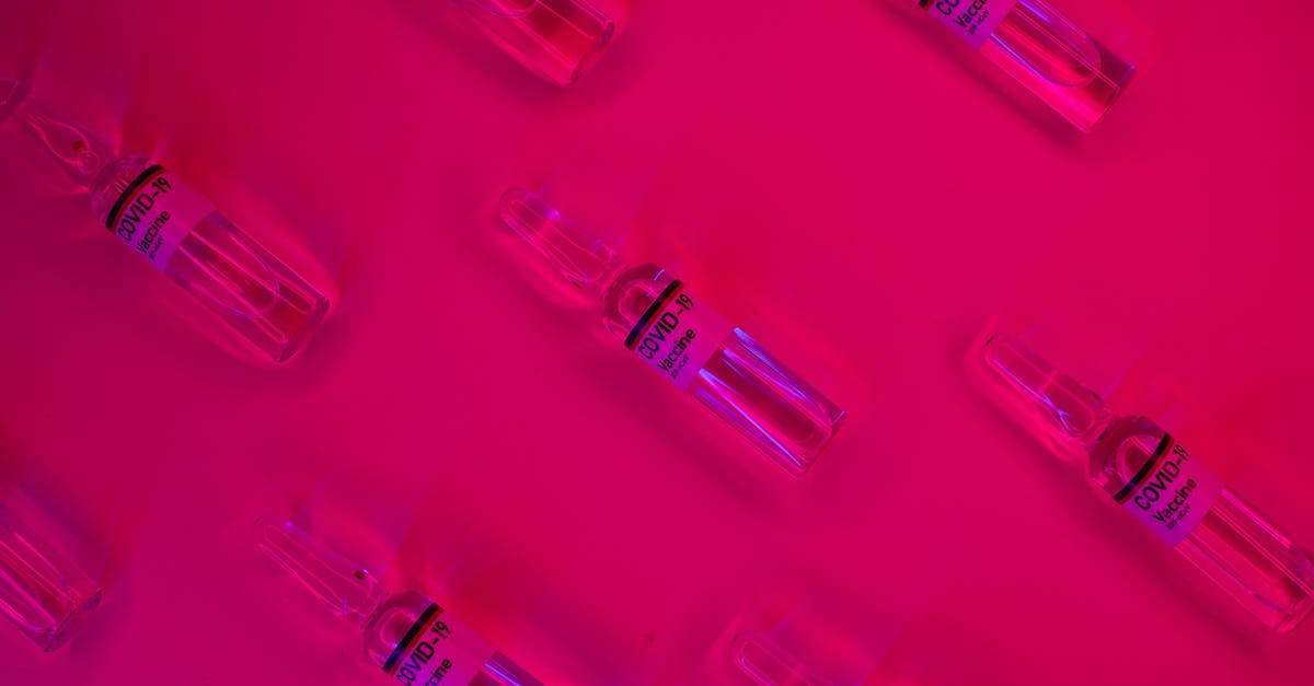 How to secure a roll-top closure bag? - Layout of doses of coronavirus vaccine in glass transparent vials placed on bright fuchsia background in studio How to secure a roll-top closure bag? - Layout of doses of coronavirus vaccine in glass transparent vials placed on bright fuchsia background in studio