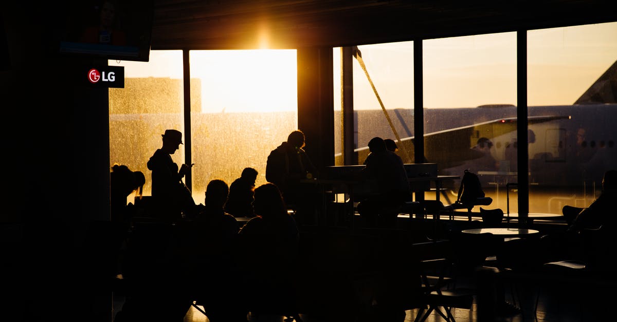 How to stay awake while waiting for a plane - Silhouette of People Sitting Inside the Airport