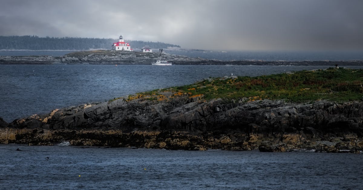 How to travel between the islands of Cape Verde? - Breathtaking scenery of aged Egg Rock Light lighthouse located on cape in wavy ocean against overcast sky on rainy day