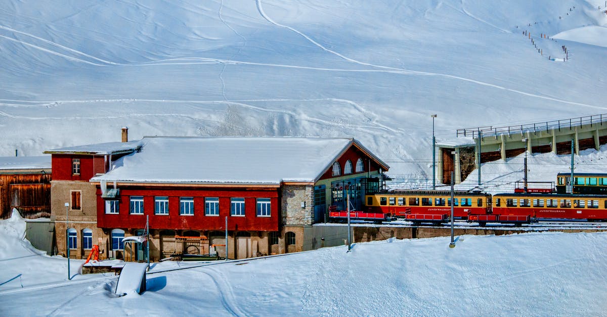 How to travel (relatively) cheaply with ICE trains in Germany? - Yellow and Red Train Beside Snowy Mountain How to travel (relatively) cheaply with ICE trains in Germany? - Yellow and Red Train Beside Snowy Mountain