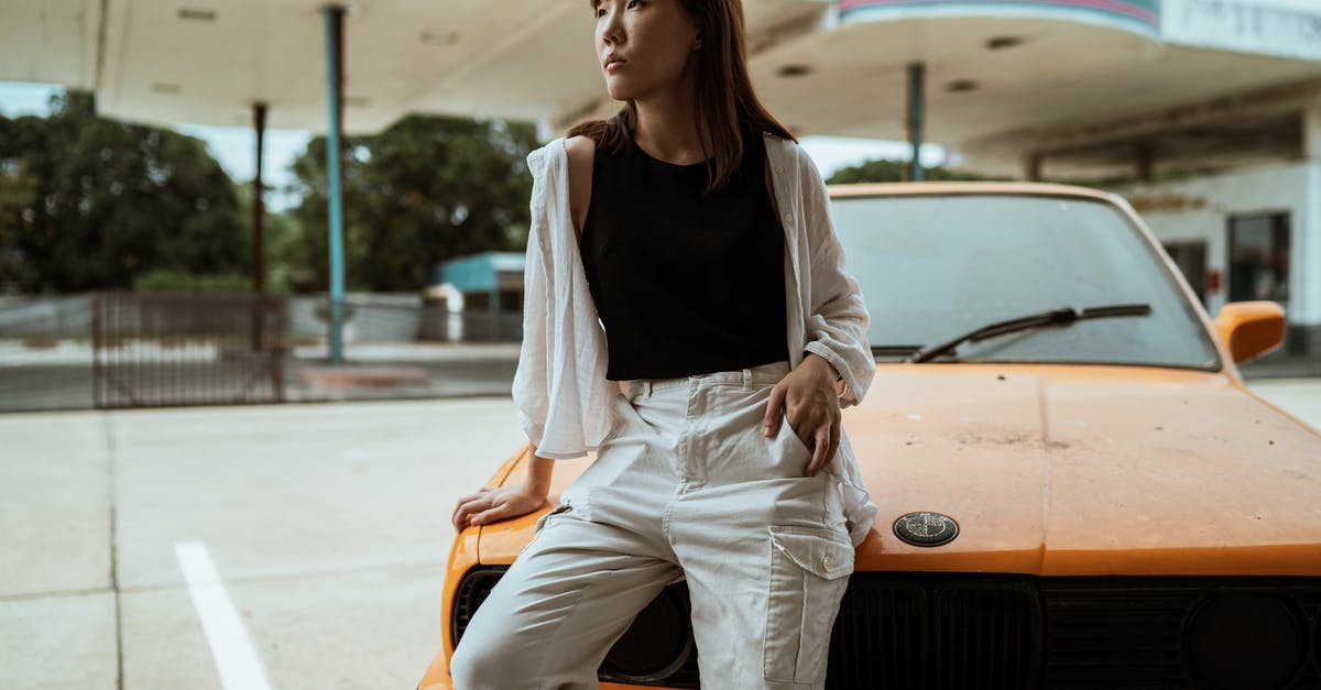 How to use a petrol/gas station in Greece? - Slim pensive Asian woman in casual wear sitting with hand in pocket on old timer automobile parked on asphalt road and looking away How to use a petrol/gas station in Greece? - Slim pensive Asian woman in casual wear sitting with hand in pocket on old timer automobile parked on asphalt road and looking away