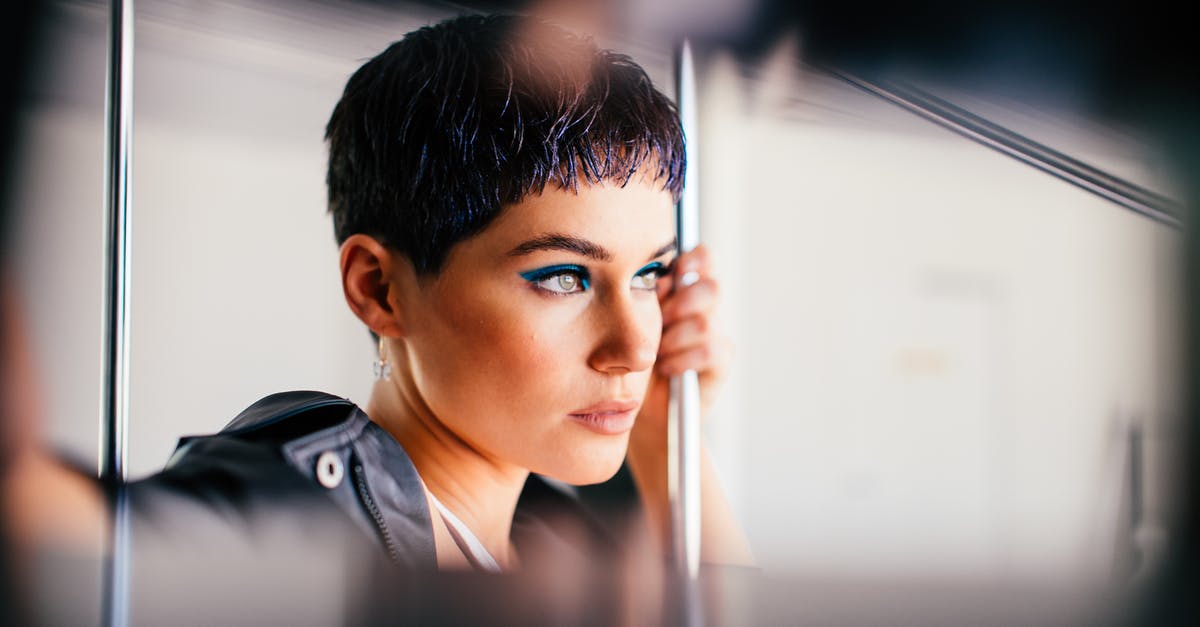 How to use public transport inside European cities (short visits)? [closed] - Fashionable young woman holding handrail and looking away thoughtfully