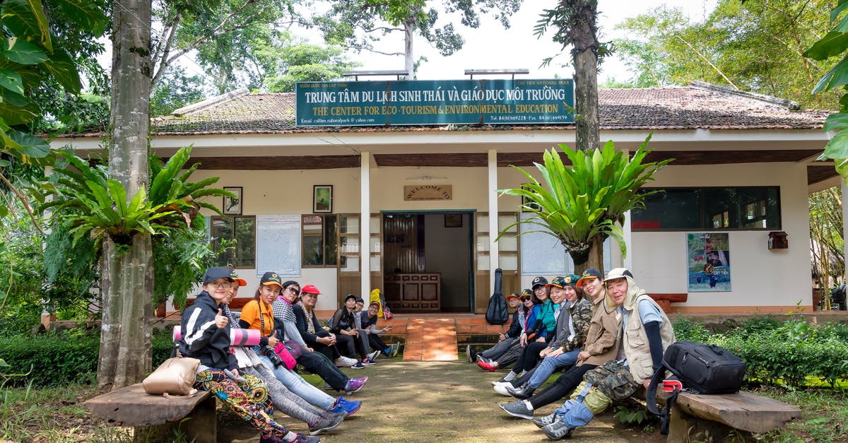 How to vet an overseas travel agency - Group of Asian tourists sitting on benches before hiking How to vet an overseas travel agency - Group of Asian tourists sitting on benches before hiking