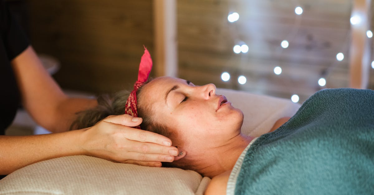 How unlikely is a discharge of passengers into the wrong concourse and what would the procedure be if it happened? [closed] - Side view of relaxed female patient with closed eyes lying on table under blanket while getting massage reiki during healing session in salon