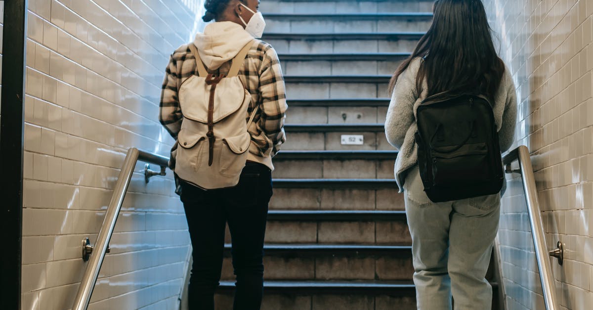 I'm American. re: COVID restrictions, can I fly through Portugal on my way to the Czech Republic in September? [closed] - Back view of African American female in mask walking on stairway in subway passage during coronavirus pandemic