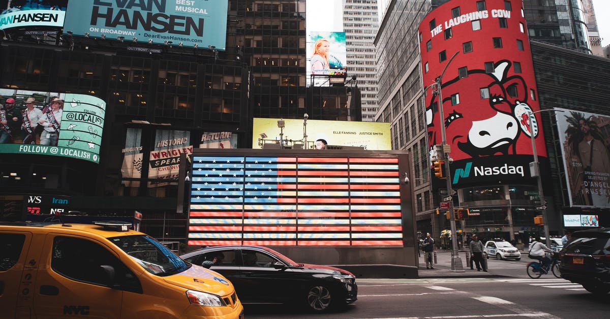I'm travelling to USA for business (B1/B2). My wife is accompanying me for tourism with B1/B2 visa. What documents does she need for immigration? - Yellow Sedan on Road Near High Rise Buildings I'm travelling to USA for business (B1/B2). My wife is accompanying me for tourism with B1/B2 visa. What documents does she need for immigration? - Yellow Sedan on Road Near High Rise Buildings