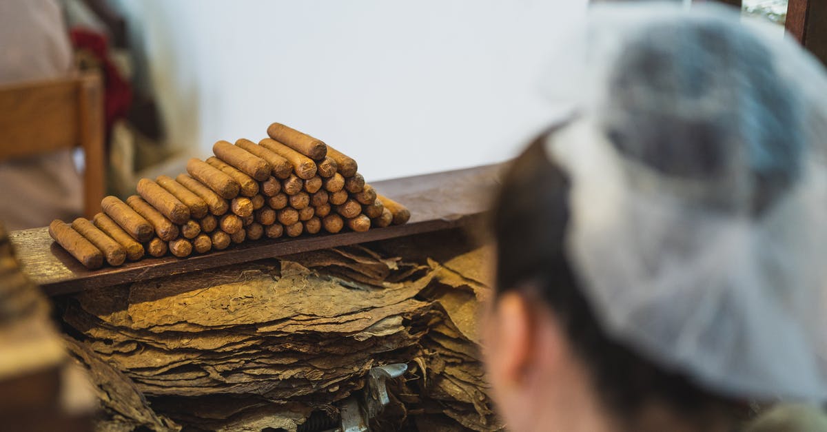 I've arrived in Paris without ID, nobody checked my passport through whole process [duplicate] - From above back view of crop anonymous female employee in transparent cap preparing tobacco near stack of cigars in fabric
