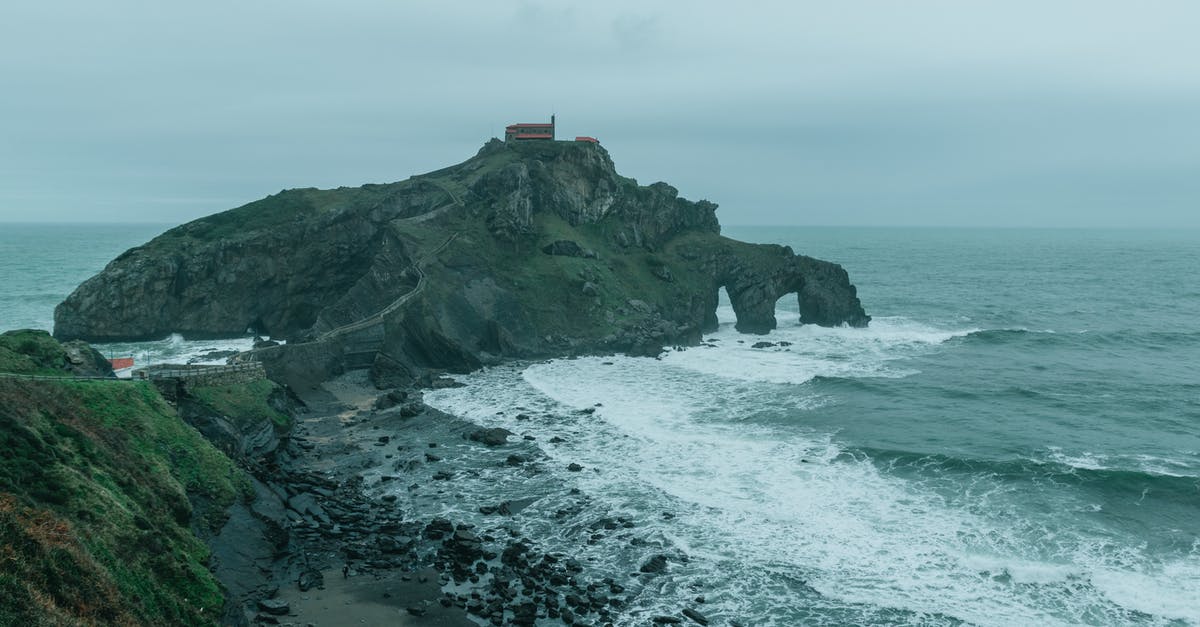 I've been arrested once in Spain, does it affect my future application for visa to Spain or any other Schengen countries? [closed] - Rocky seacoast and island with church under foggy sky