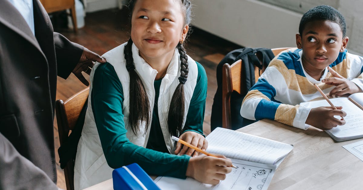 I-539 Visa Extension Question - Crop black teacher talking with smart multiethnic boy and girl siting at desk with notepads I-539 Visa Extension Question - Crop black teacher talking with smart multiethnic boy and girl siting at desk with notepads