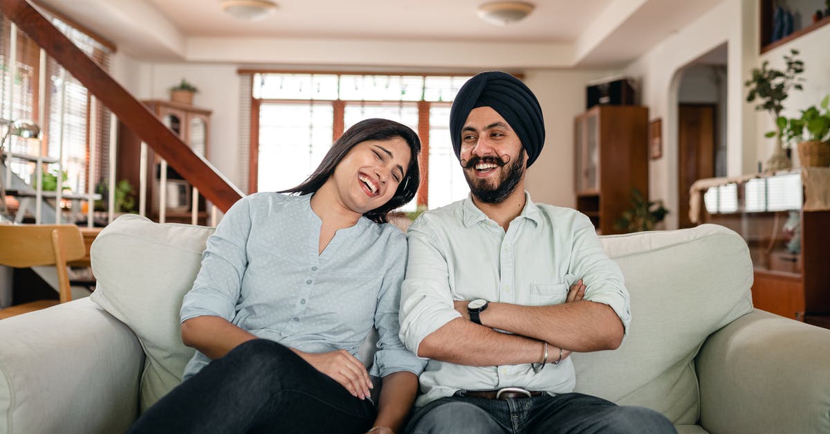 I am a UK citizen living in the Netherlands with my Indonesian wife we both have permanent residence [closed] - Optimistic young Indian man and woman in casual outfits laughing and having fun while resting together on comfortable sofa during weekend