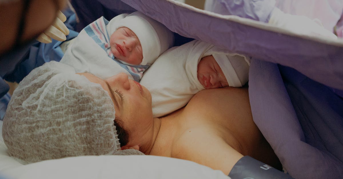 I am applying for a UK Visitor Visa. Can I plan to give birth in an NHS hospital (paying for it), or must I deliver in a fully private hospital? - Woman with her Newborn Twins on a Hospital Bed