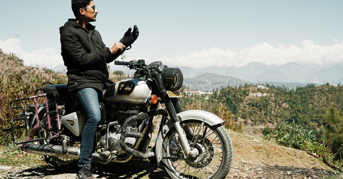 I have a cool suitcase. Might be tricky to ride a motorbike. Looking for a strap allowing to carrying it as a backpack? - Cool biker on high hill observing landscape