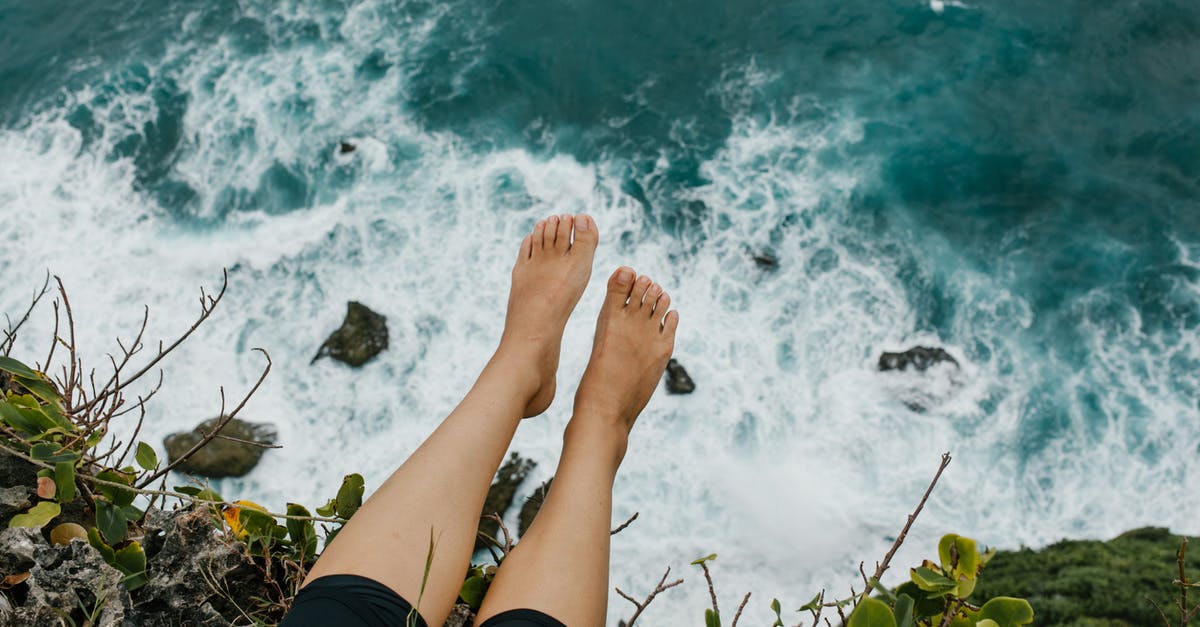 I have a travel voucher from American Airlines. Can I use part of it now, and the rest later? - Woman sitting on edge of cliff above foaming sea I have a travel voucher from American Airlines. Can I use part of it now, and the rest later? - Woman sitting on edge of cliff above foaming sea